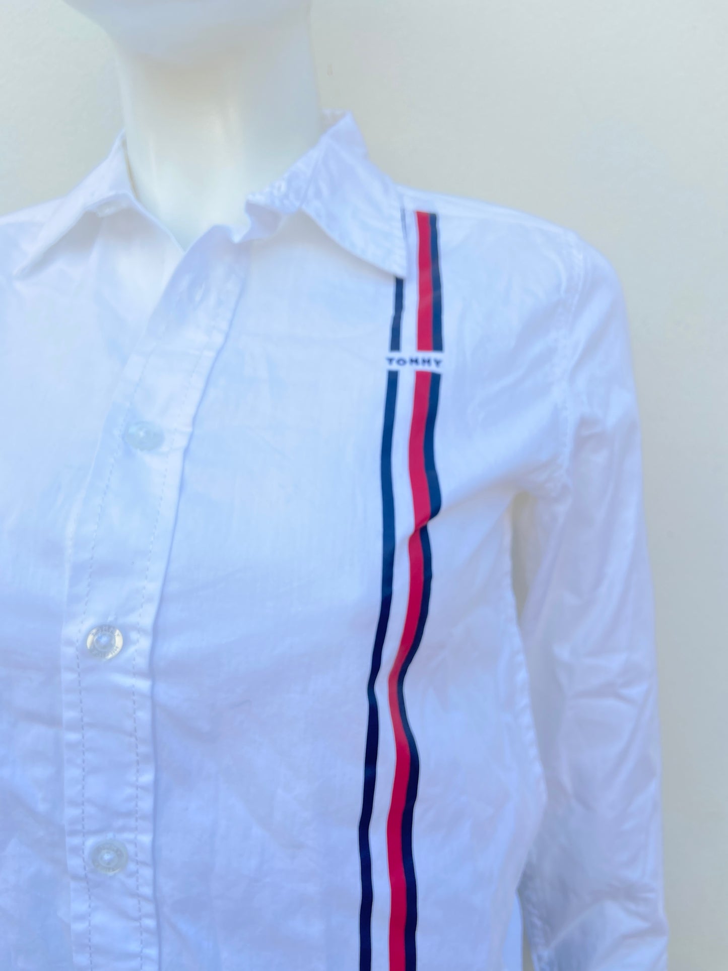 Camisa Tommy Hilfiger original blanca con líneas roja y azul en frente.