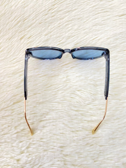 Lentes, negros con montura negra y dorada y micas de color azul, estilo gato, con protección UV 100% Polycarbonate.