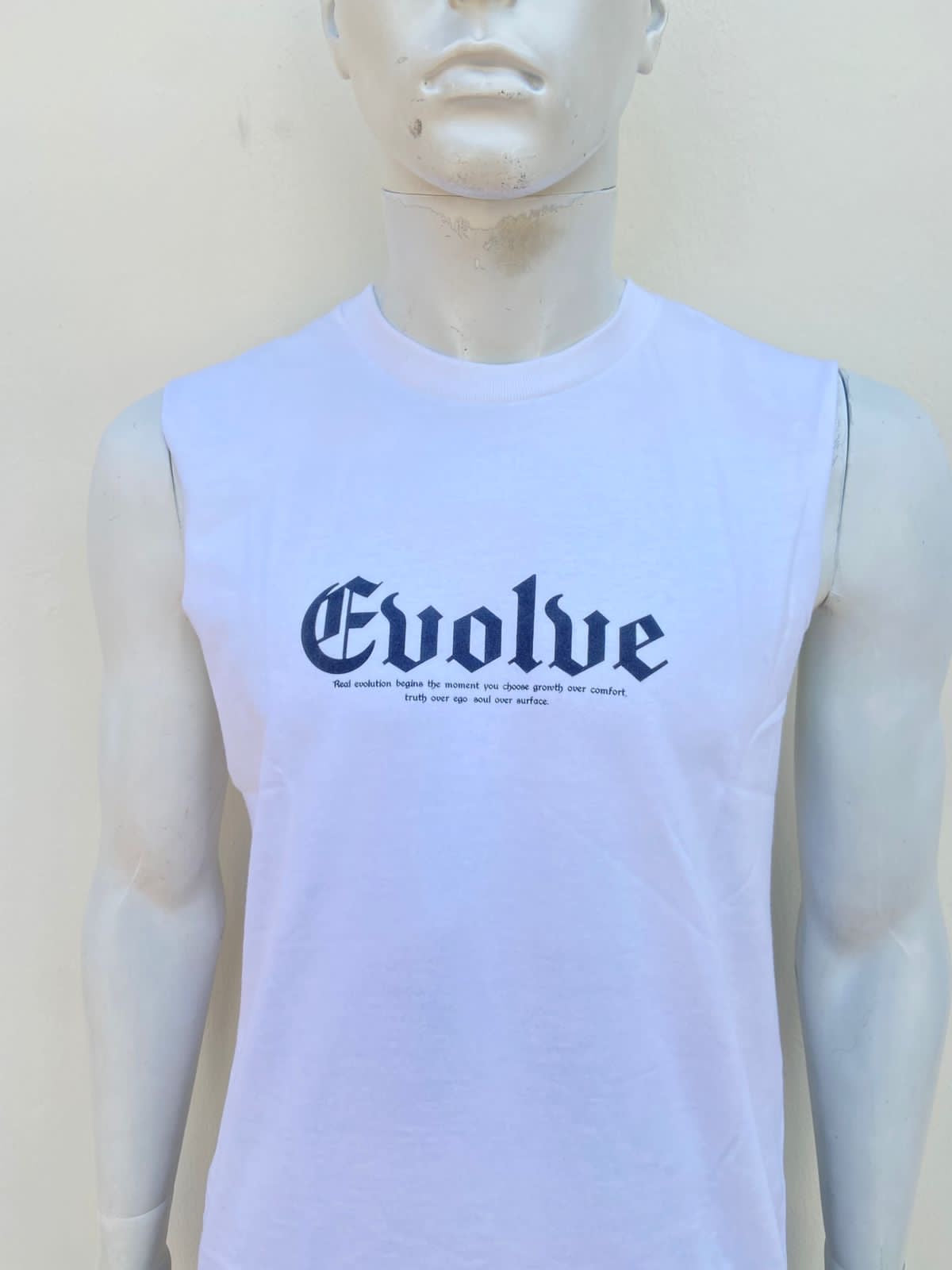 Franela blanca con letra en color negra al frente EVOLVE y diseño atras.