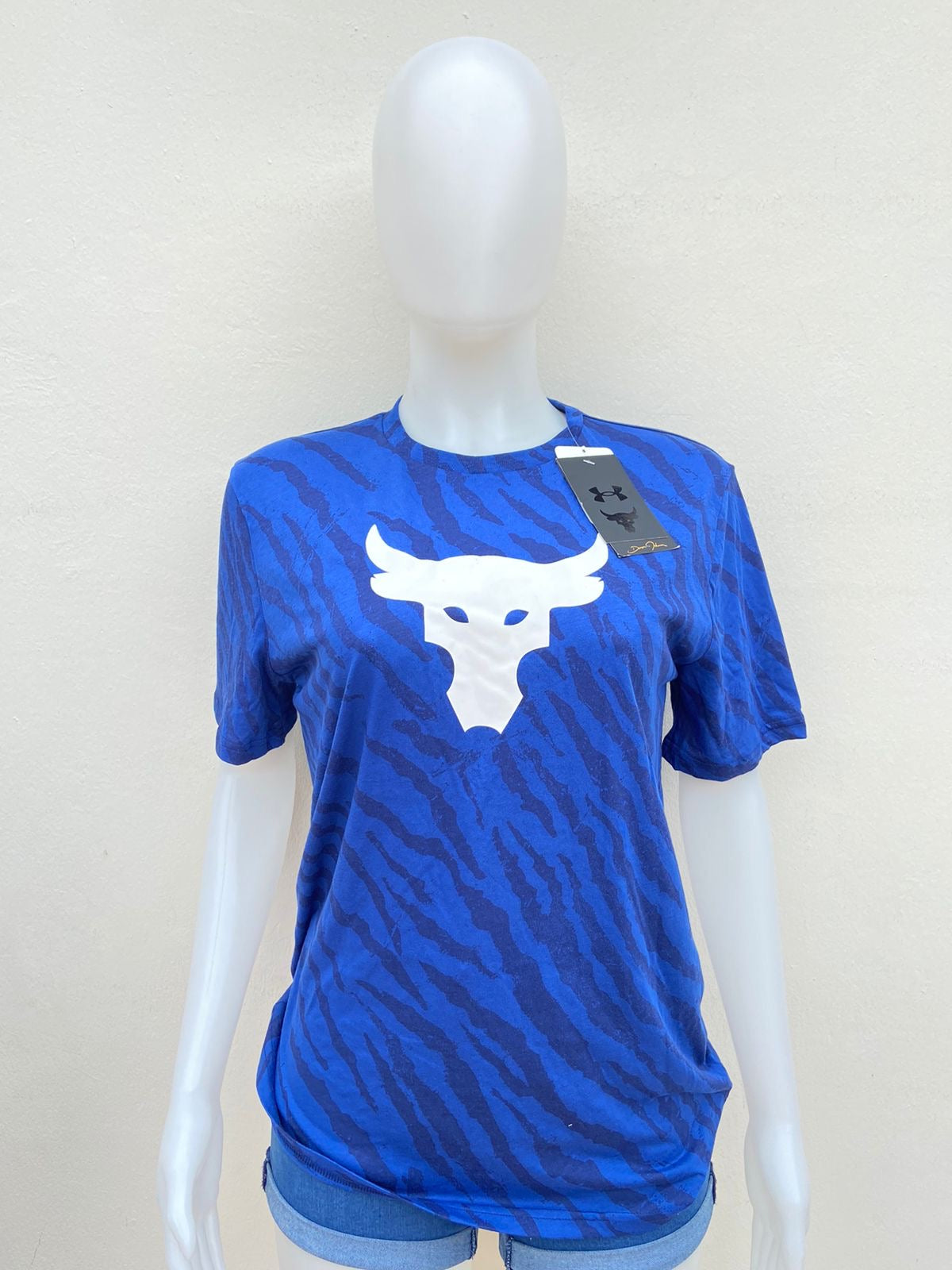 T-shirt Under Armour original azul con estampado de animal print y logotipo de un toro en blanco.