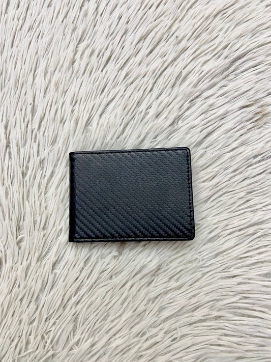 Billetera pequeña en color negra con clip para billetes, espacios para tarjetas y espacio transparente para cedula o licencia.