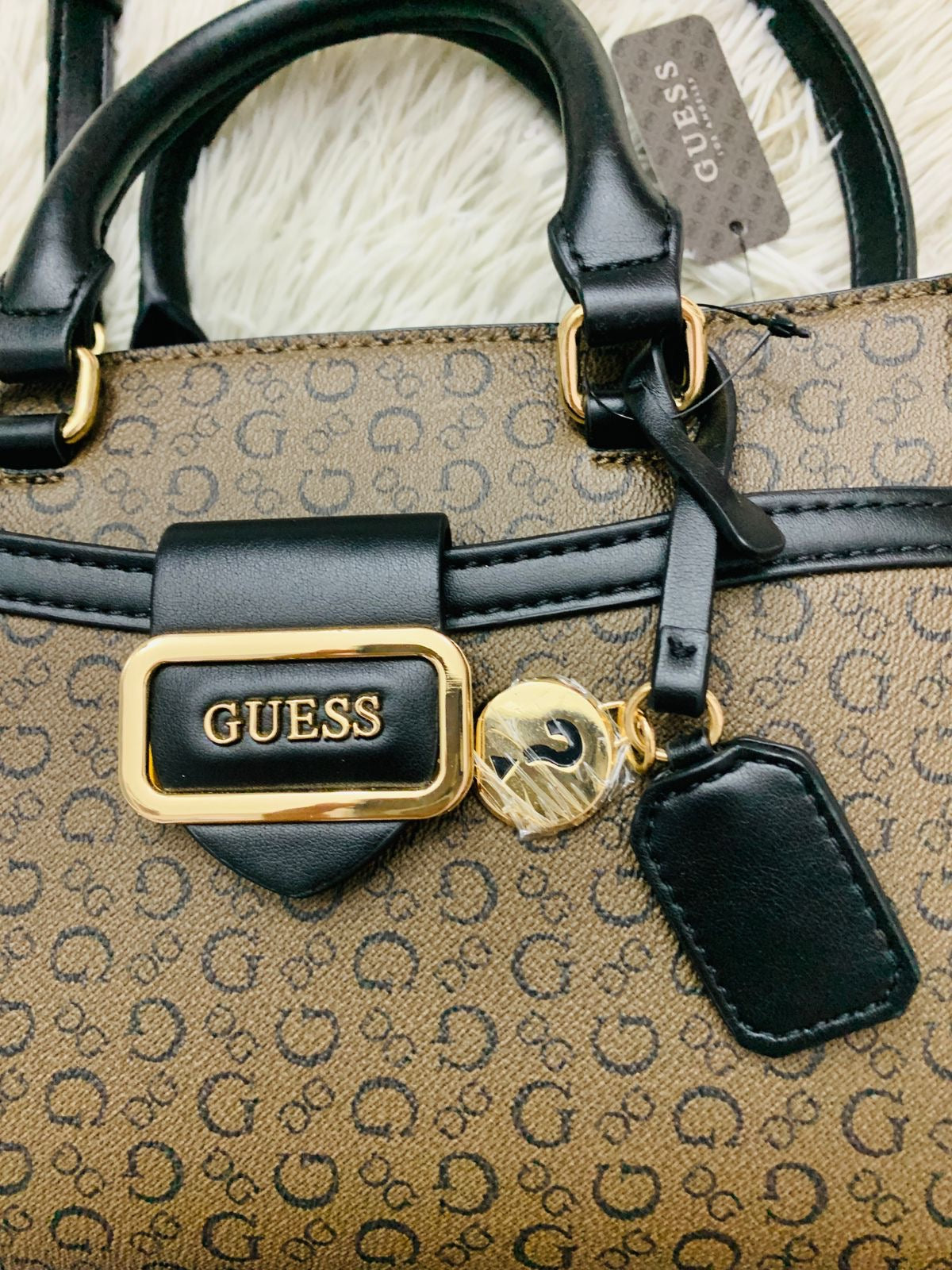 Cartera Guess original marrón con estampado de letras en color negro.