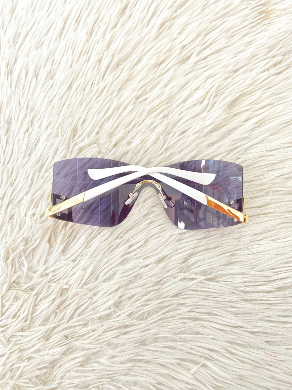 Lentes, negro con montura en color blanco y diseño de una G invertida dorada.