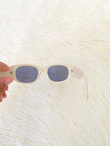 Lentes color crema con estampado de hojas tropicales en las patillas, estilo rectangular, con protección UV 100%.