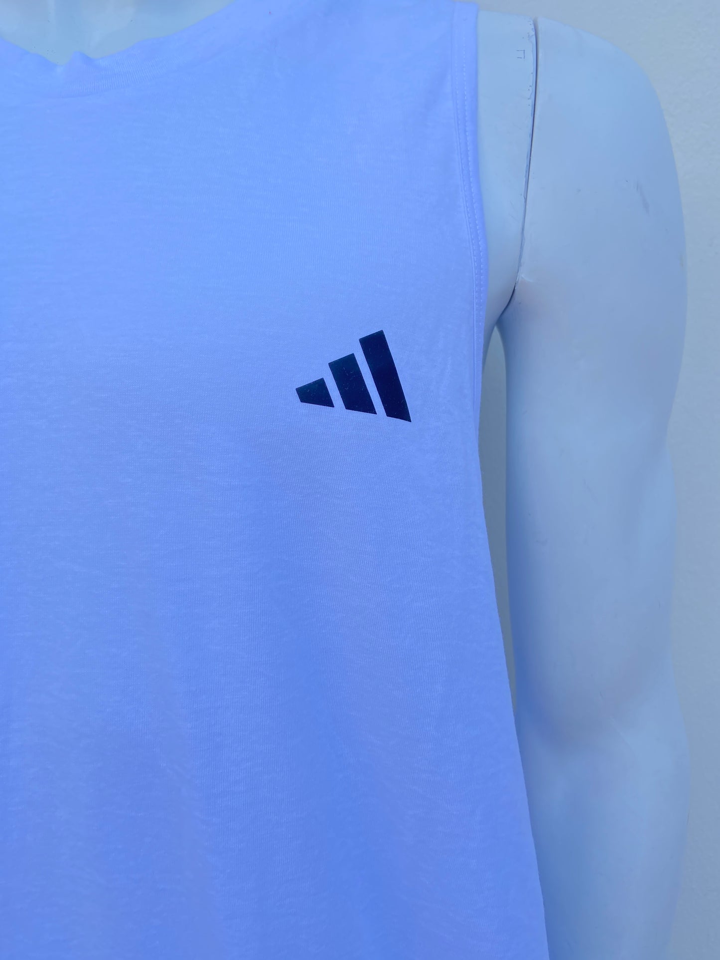Franela Adidas original blanca con logotipo de la marca al lado.