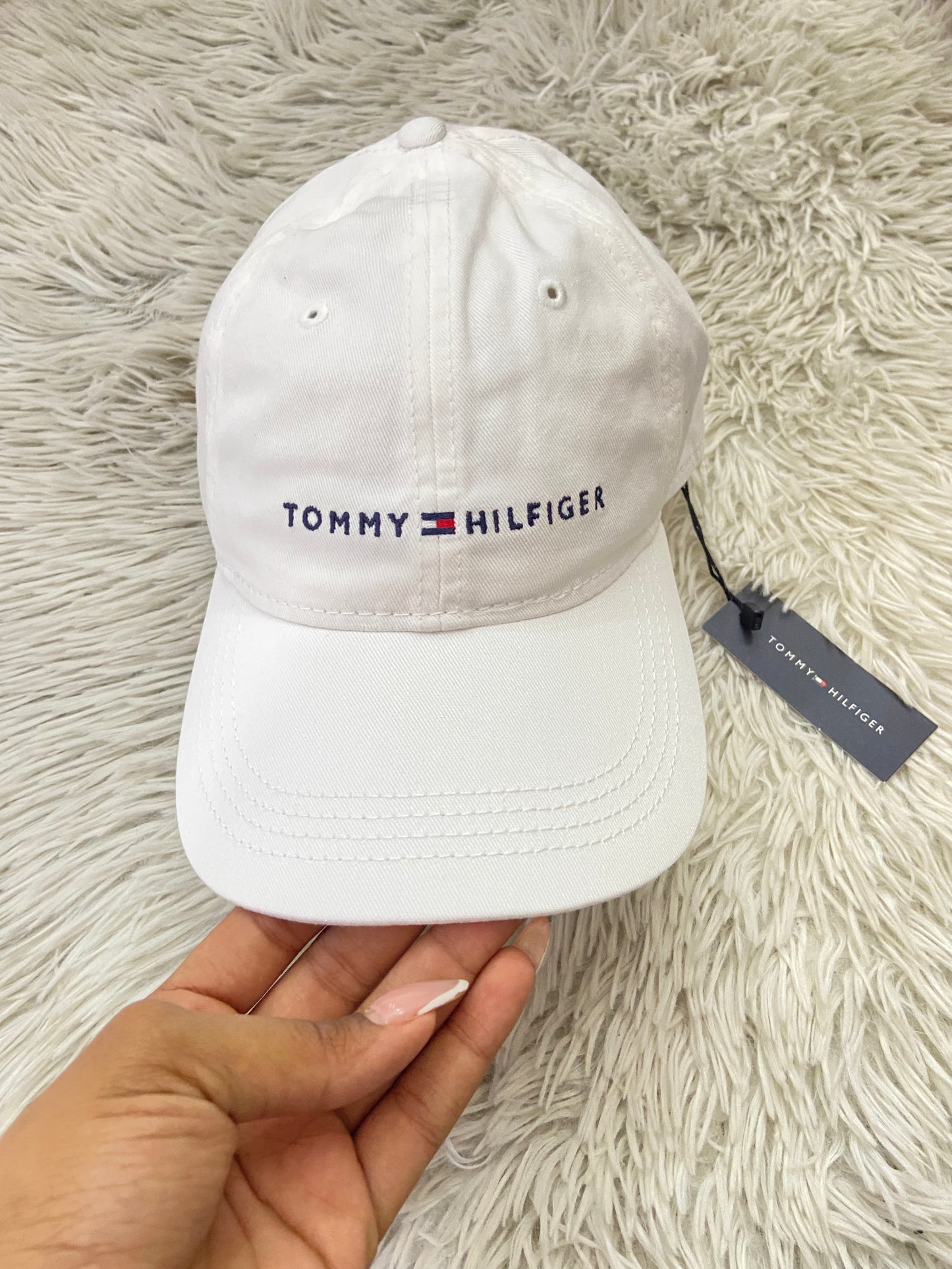 Gorra Tommy Hilfiger original blanca con letras TOMMY HILFIGER en azul y correa en marrón.