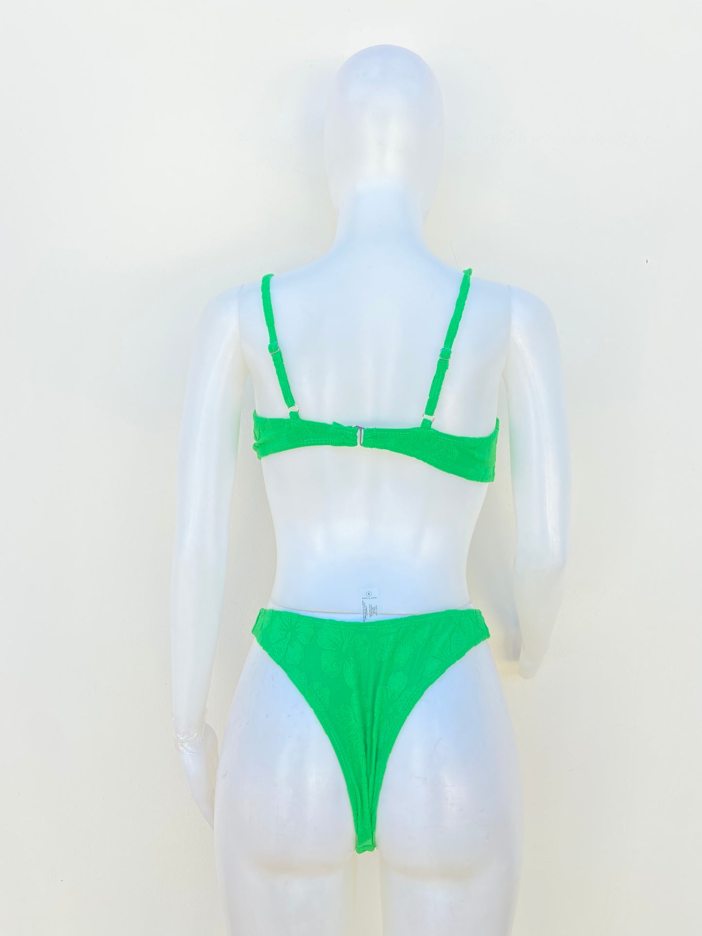 Biquini, verde con estampado de flores del mismo color y lazo enfrente.