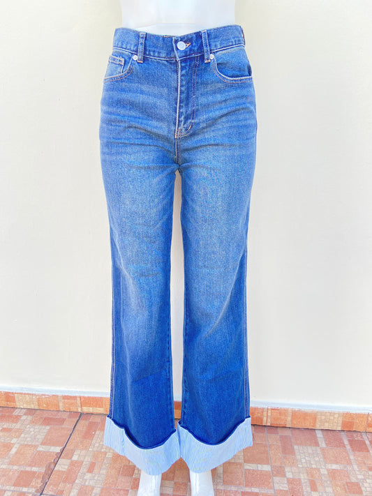 Pantalon Jean azul con tela azul con rayas blancas abajo, alto y con botón en color plateado.