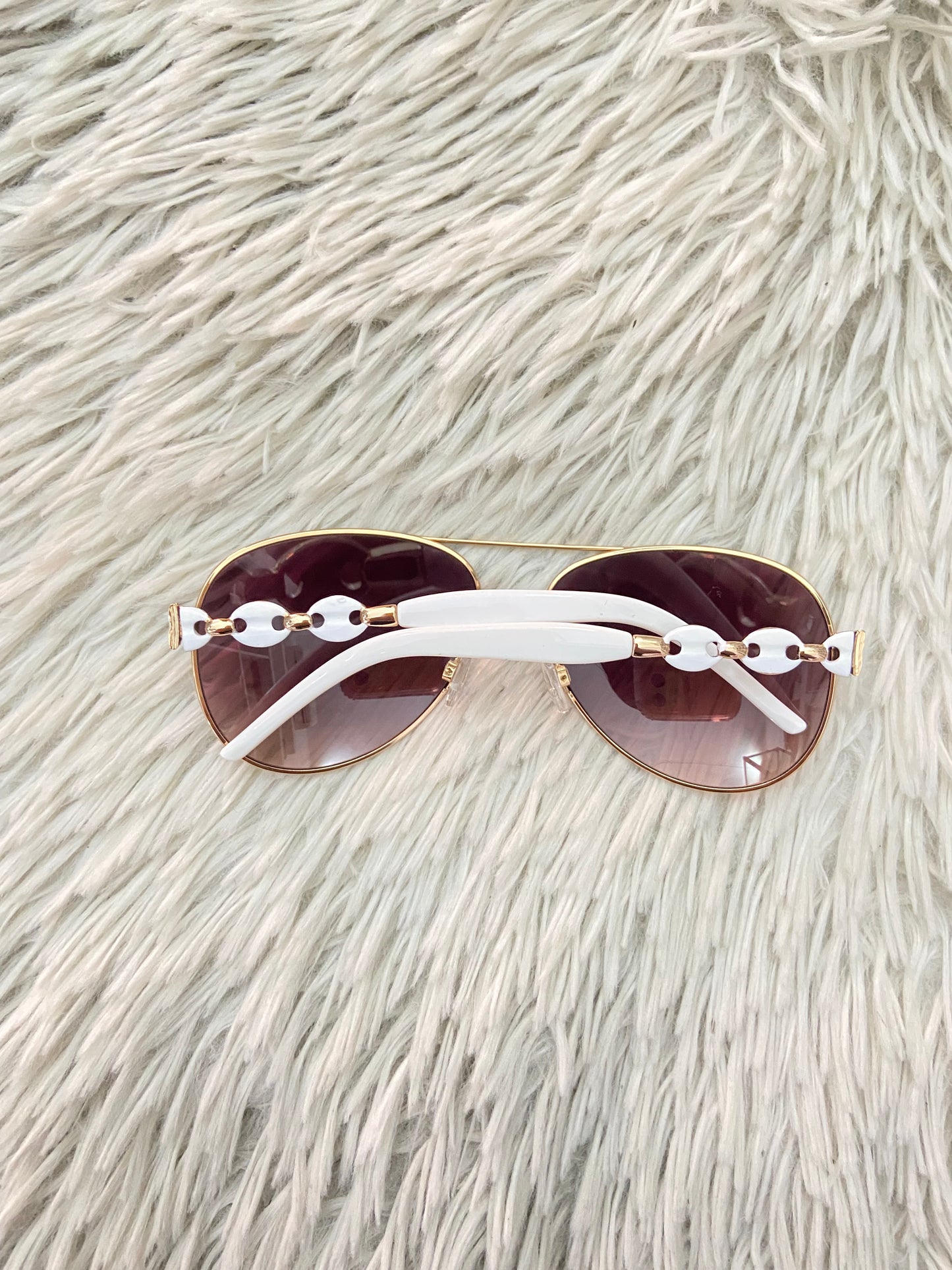 Lentes, con micas marrones y montura en color blanco.