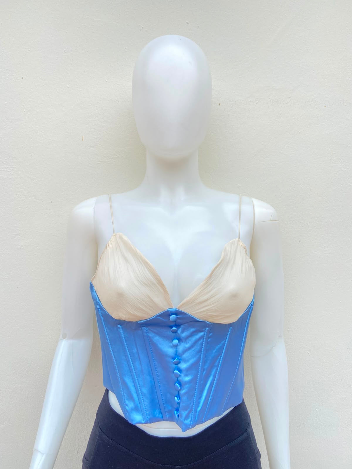 Top/corset azul con tela color crema arriba.