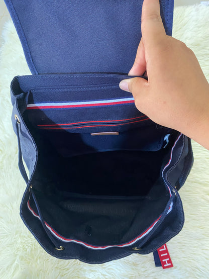Mochila Tommy Hilfiger original en color azul marino, nombre TOMMY en grande en un bolsillo con el fondo rojo, varios compartimentos, súper espacioso.