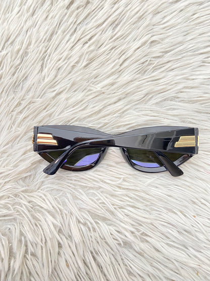 Lentes, diseñados con protección UV 100-400 para proteger tu visión. Negro con micas en color morado/ azul y detalles dorado.