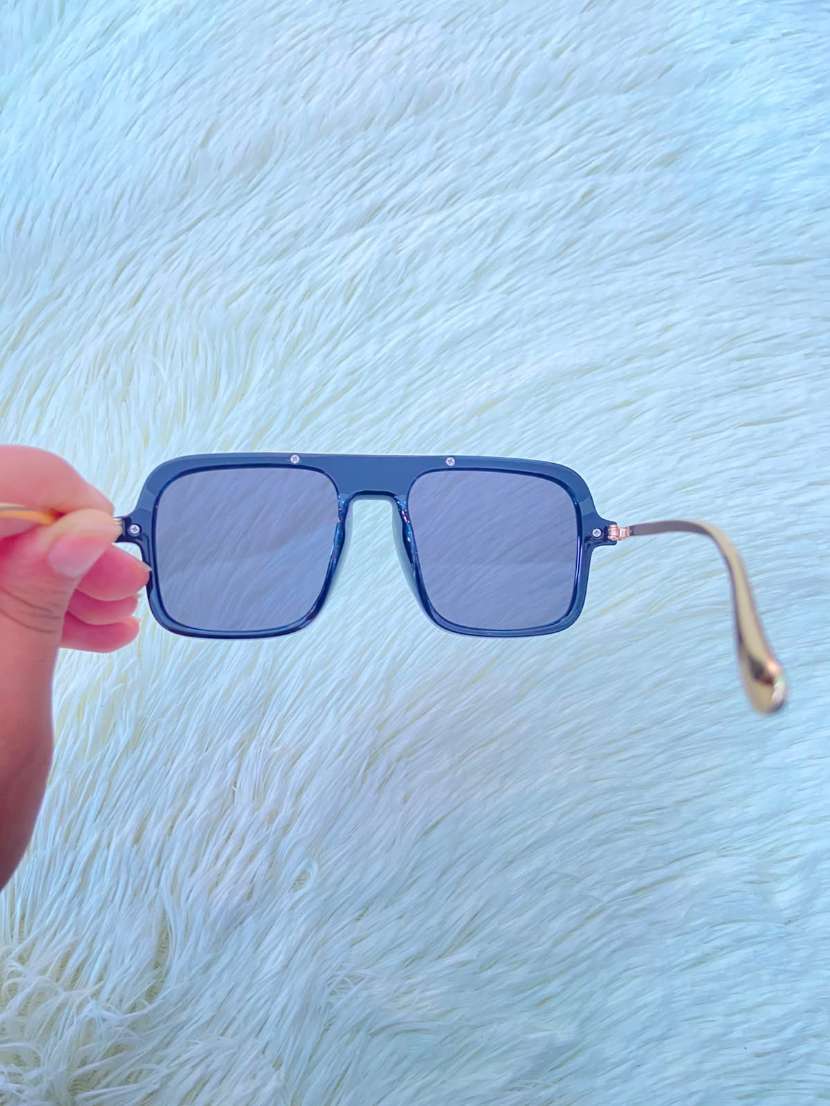 Lentes, negros con detalle dorado al frente y patillas doradas.