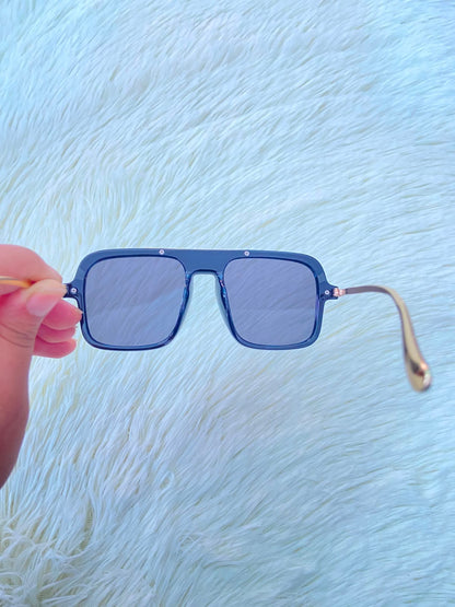 Lentes, negros con detalle dorado al frente y patillas doradas.