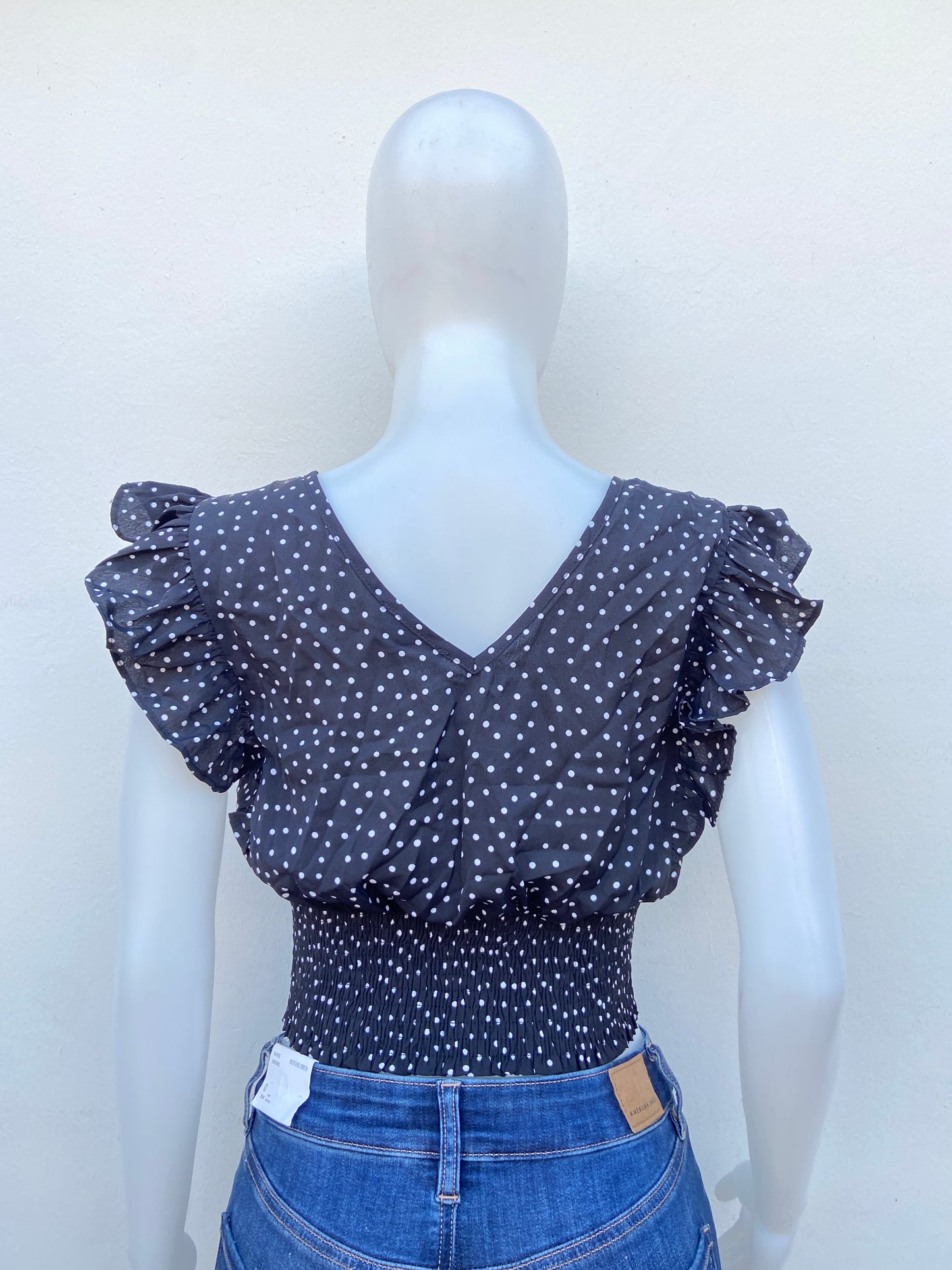 Blusa negra con estampado de bolitas blancas.