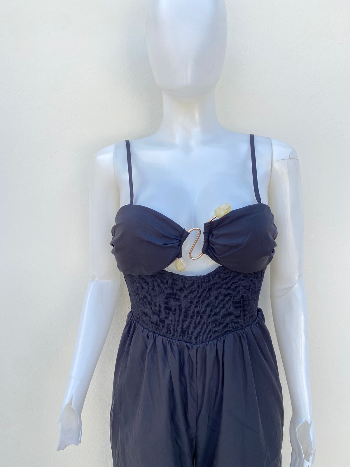 Enterizo, negro con broche en frente en color dorado.
