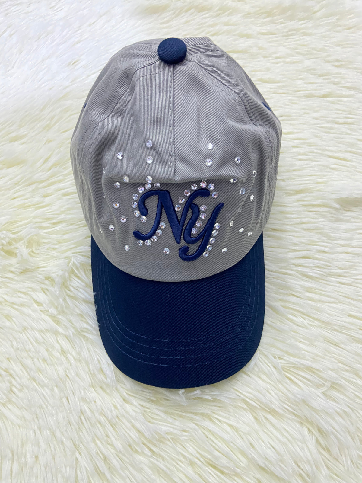Gorra, gris con azul marino y letras NY y detalles de diamantes, para niños.