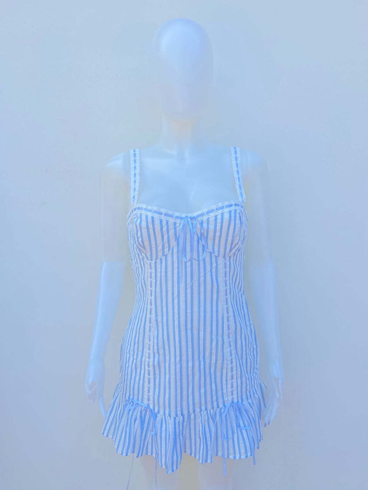 Vestido azul claro con rayas blancas con encaje y lazo en el medio en color azul
