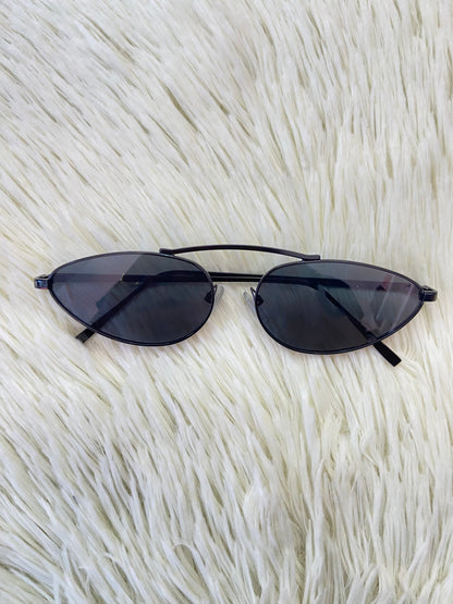Lentes, negros pequeños con micas claras y montura fina.