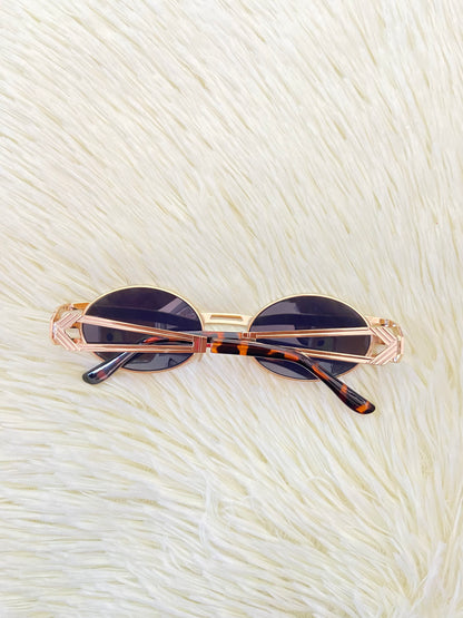 Lentes, negros con montura dorada, estilo ovalo, con protección UV 100-400.
