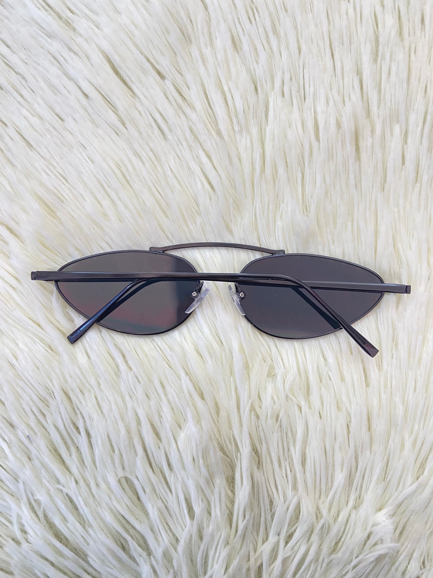 Lentes, negros pequeños con micas claras y montura fina.