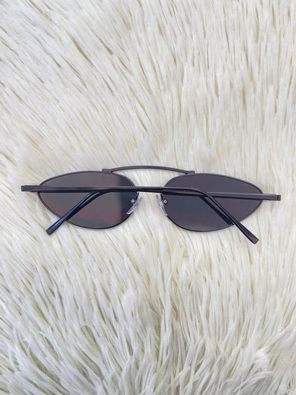 Lentes, negros pequeños con micas claras y montura fina.