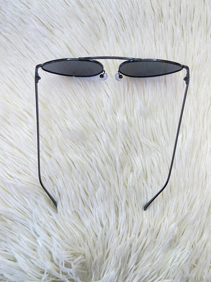 Lentes, negros pequeños con micas claras y montura fina.