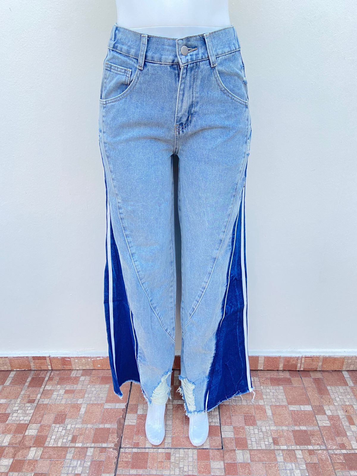 Pantalon jean azul claro con degradado blanco, tela azul oscura con blanco abajo, rotos y con pretina ajustable, ancho.