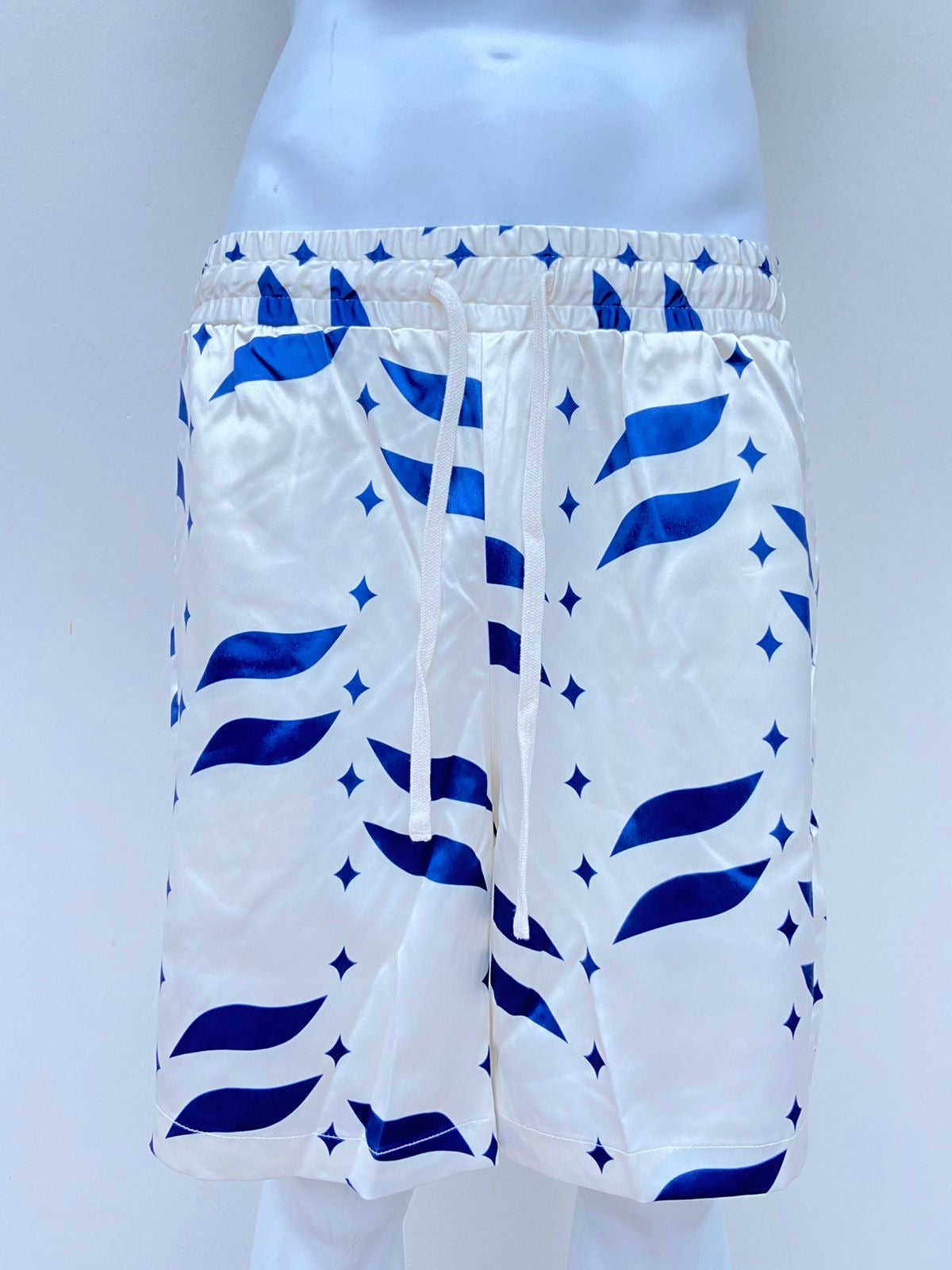 Bañador Baggy en color crema con detalles en color azul.