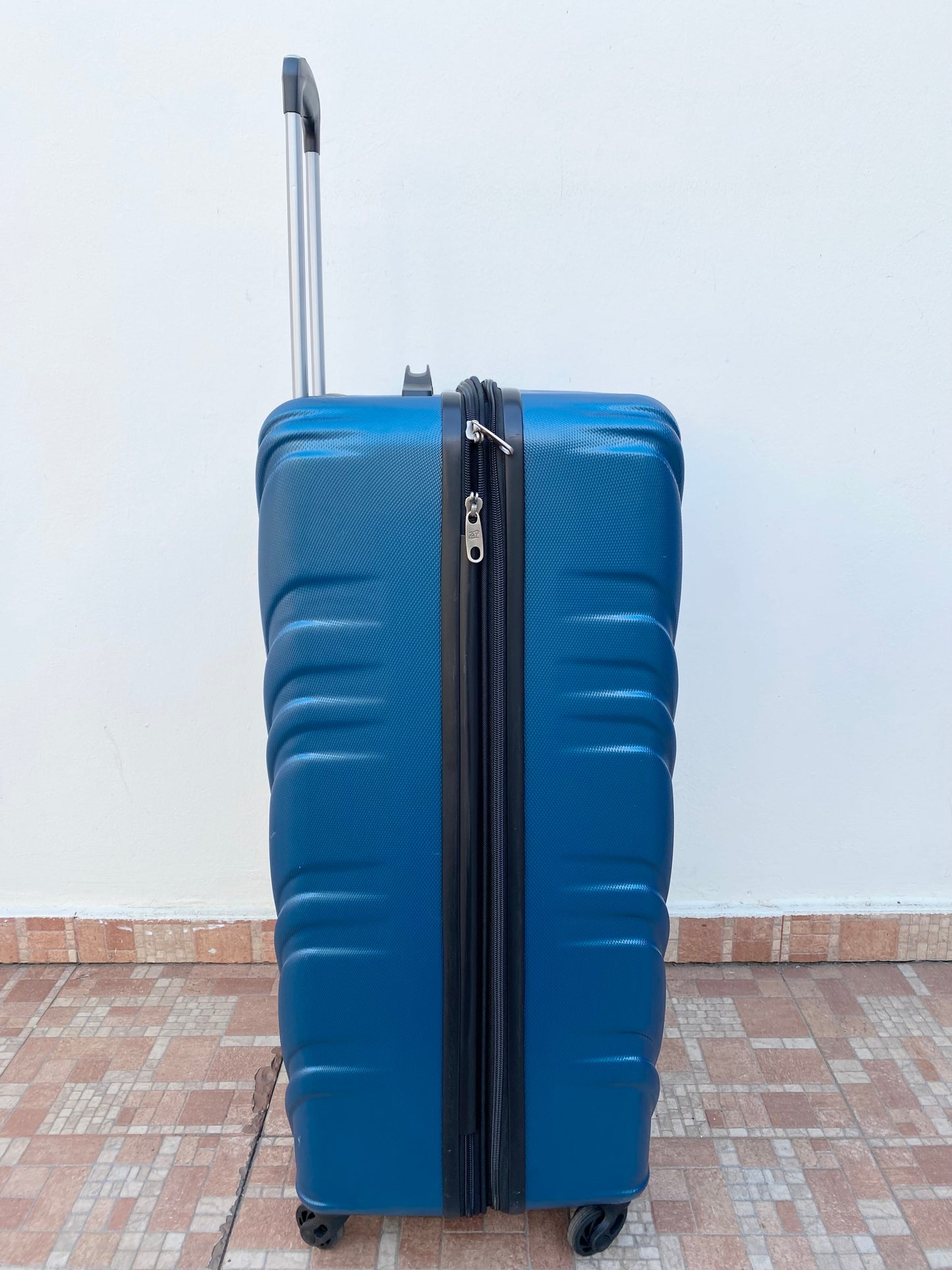 Maleta American Tourister original azul con negro y placa de la marca en frente.