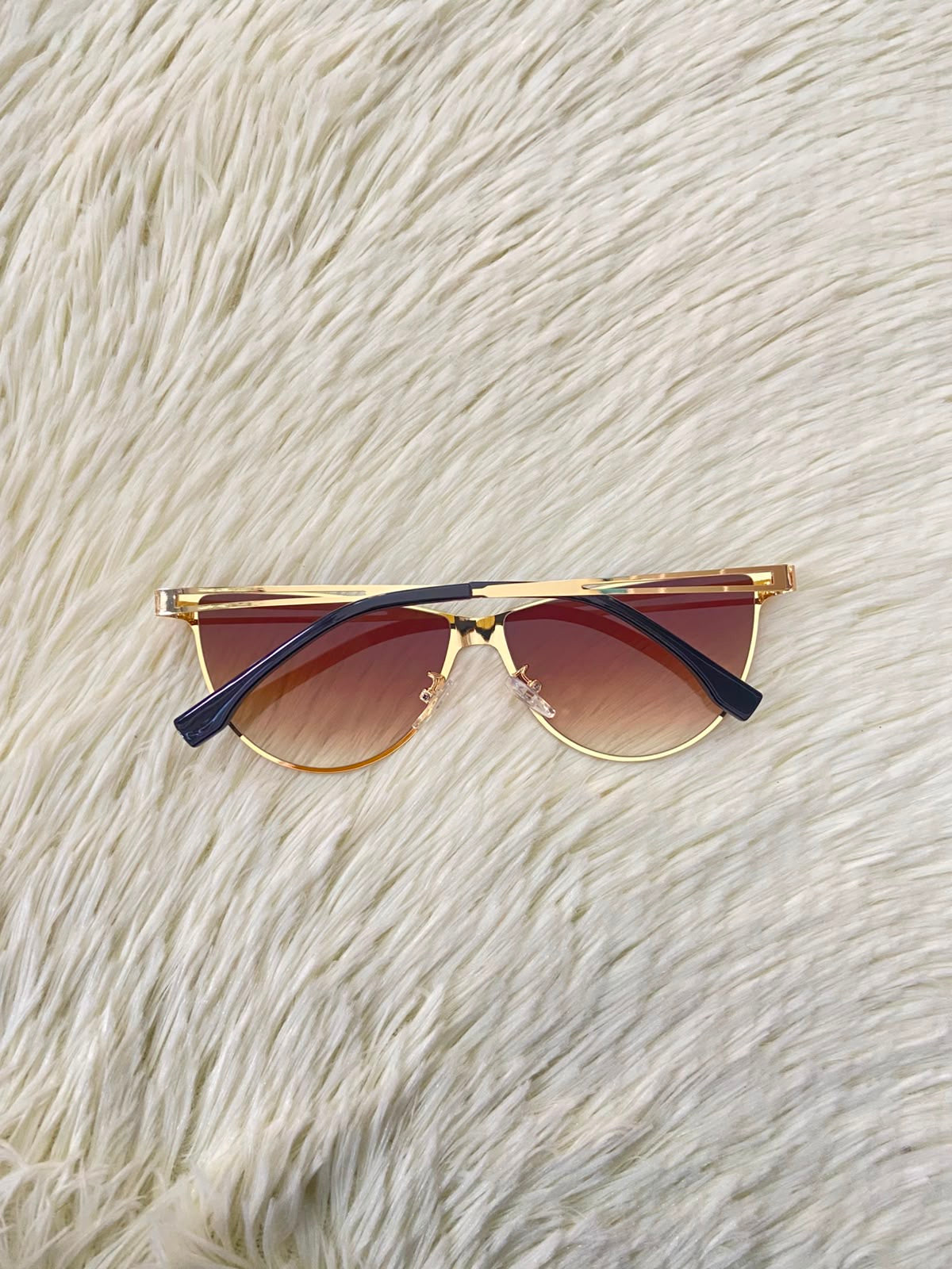 Lentes, negro con montura dorada micas marrones y patillas negras.