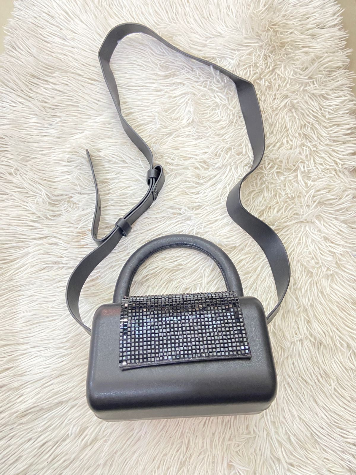 Cartera negra con detalles de brillo y correa de cuero