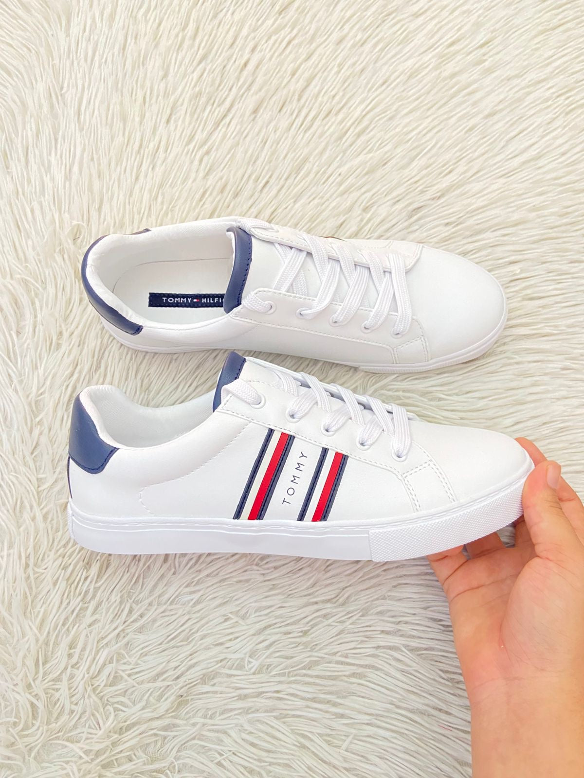 Tenis Tommy Hilfiger Original en color blanco con bandera de la en los lados y letra Tommy en el medio