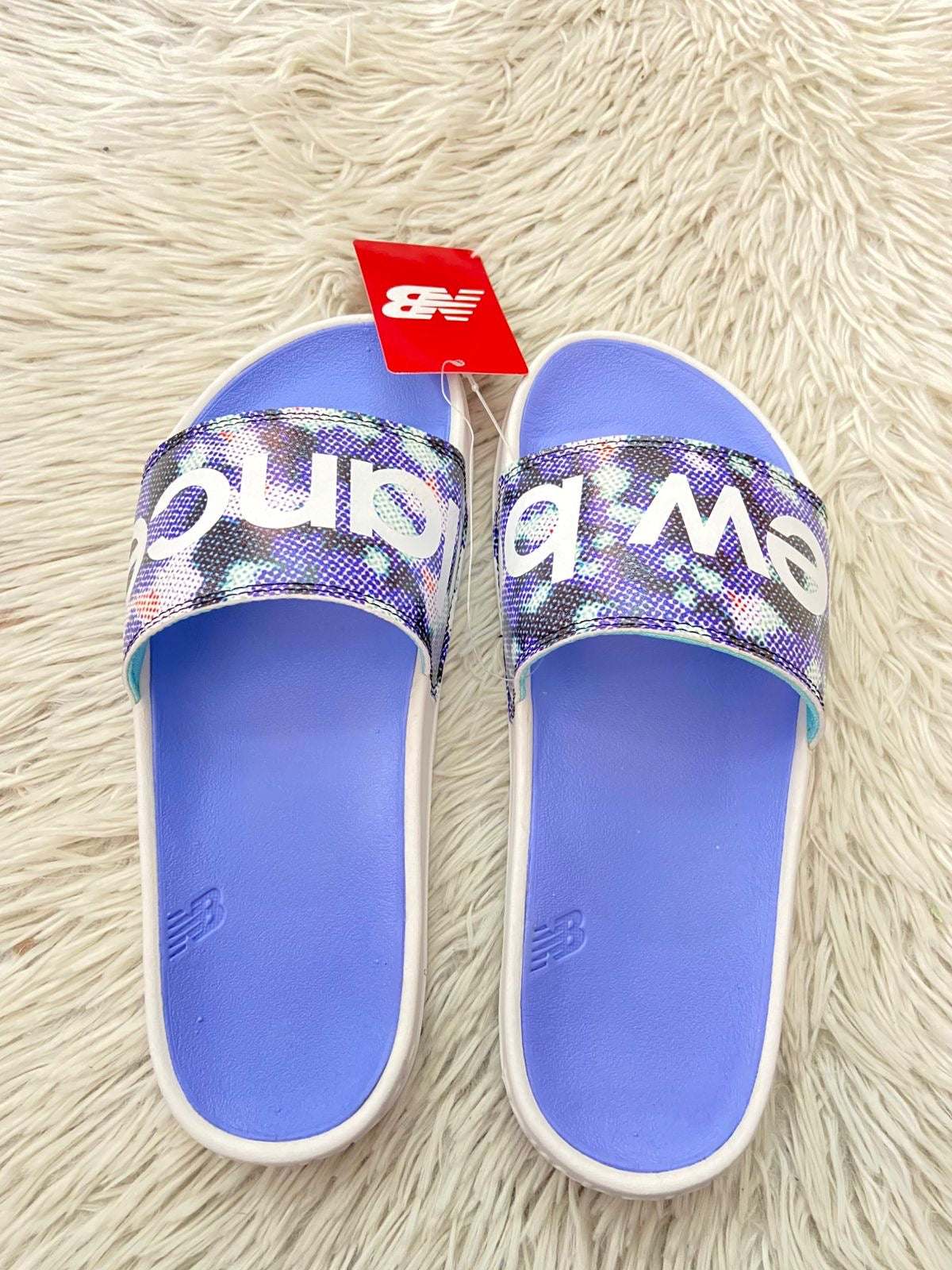 Sandalias NEW BALANCE original, azul claro con blanco y letras de la marca en frente.