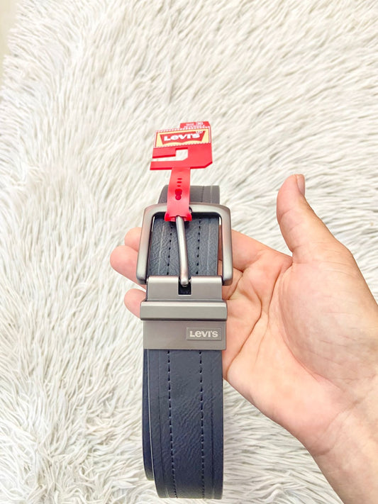 Correa LEVI’S Original en color negra con evilla en color negra y placa de la marca al frente, fondo color marron.