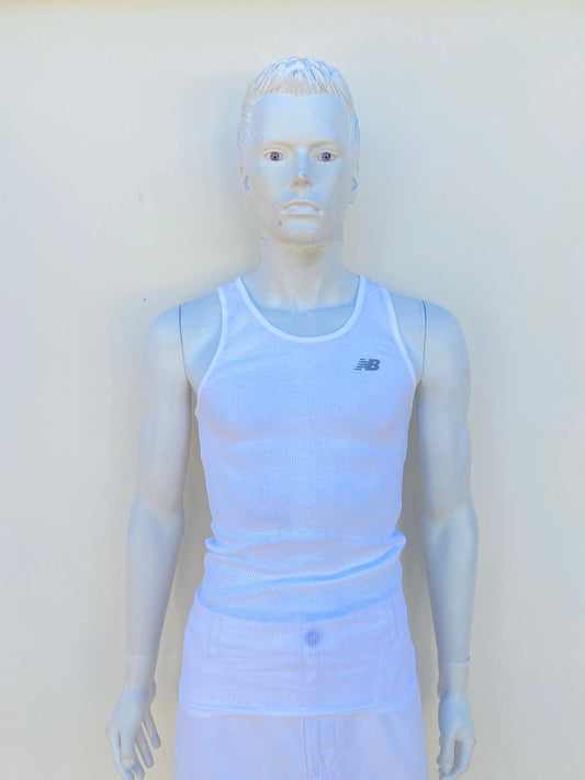 Franela New Balance en color blanca con logotigo de la marca al frente en color gris.