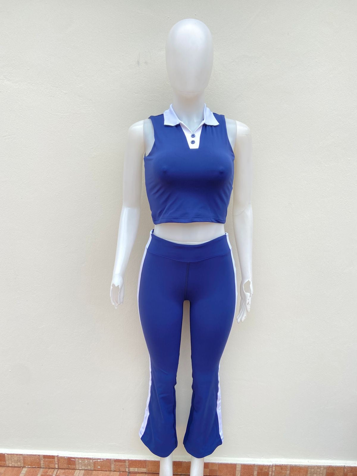 Conjunto top y legging en color azul marino con lineas blancas en los lados, top sin mangas y cuello blanco.