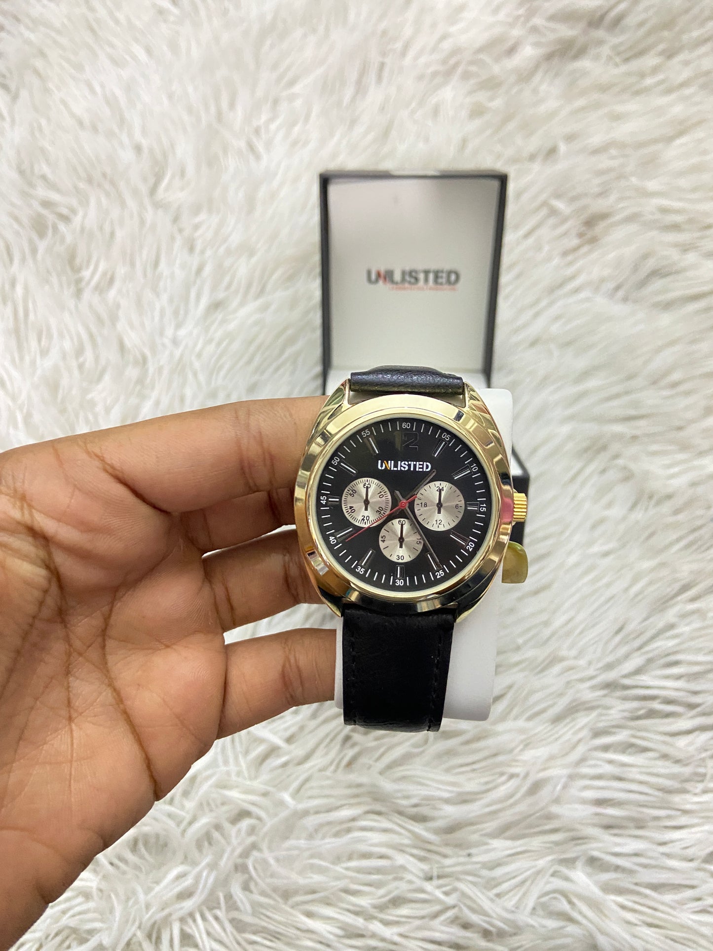 Reloj UNLISTED KENNETH COLE original negro con detalles en color dorado.