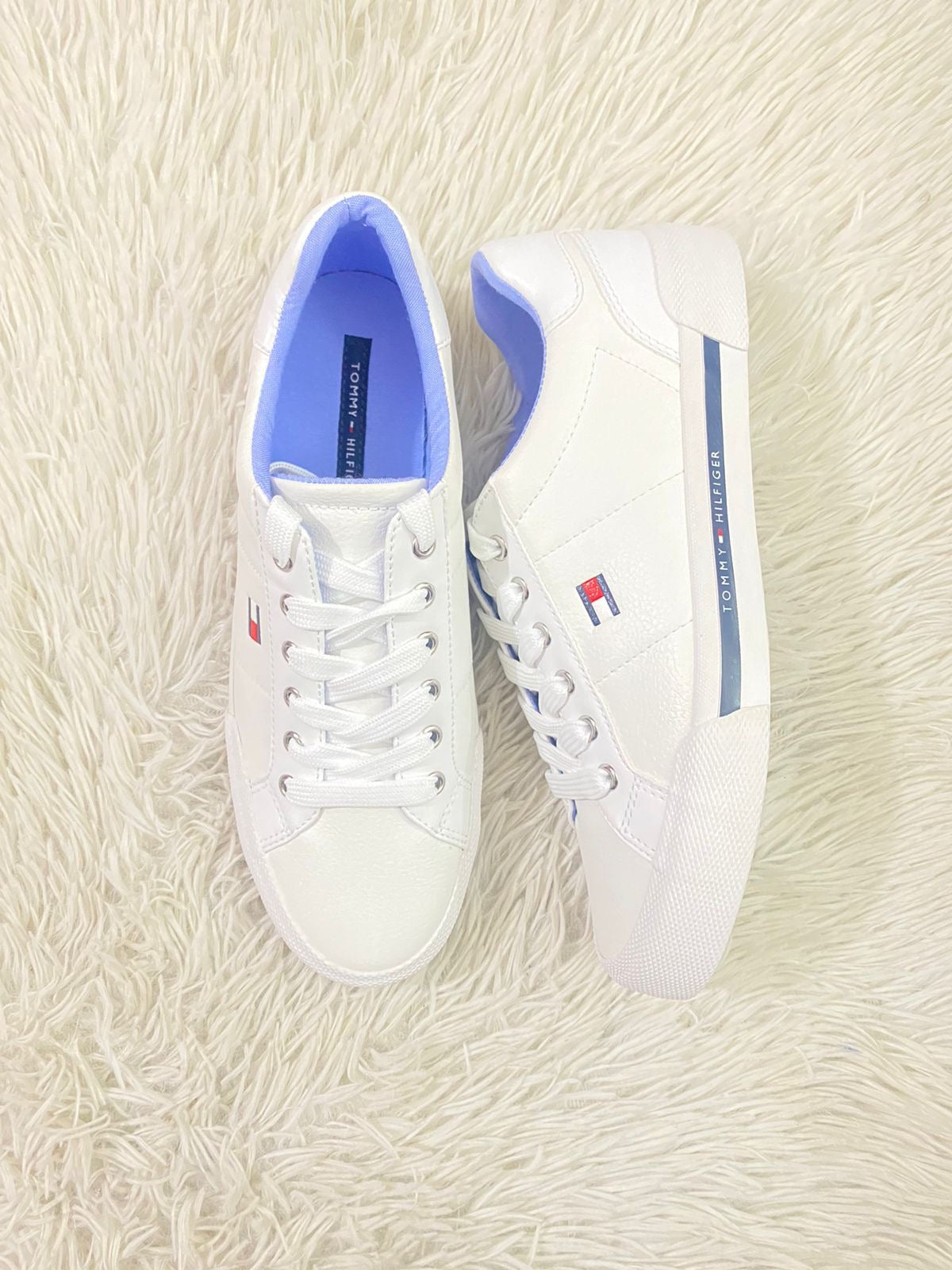 Tenis Tommy Hilfiger original blanco con línea azul y letras de la marca en  blanco.