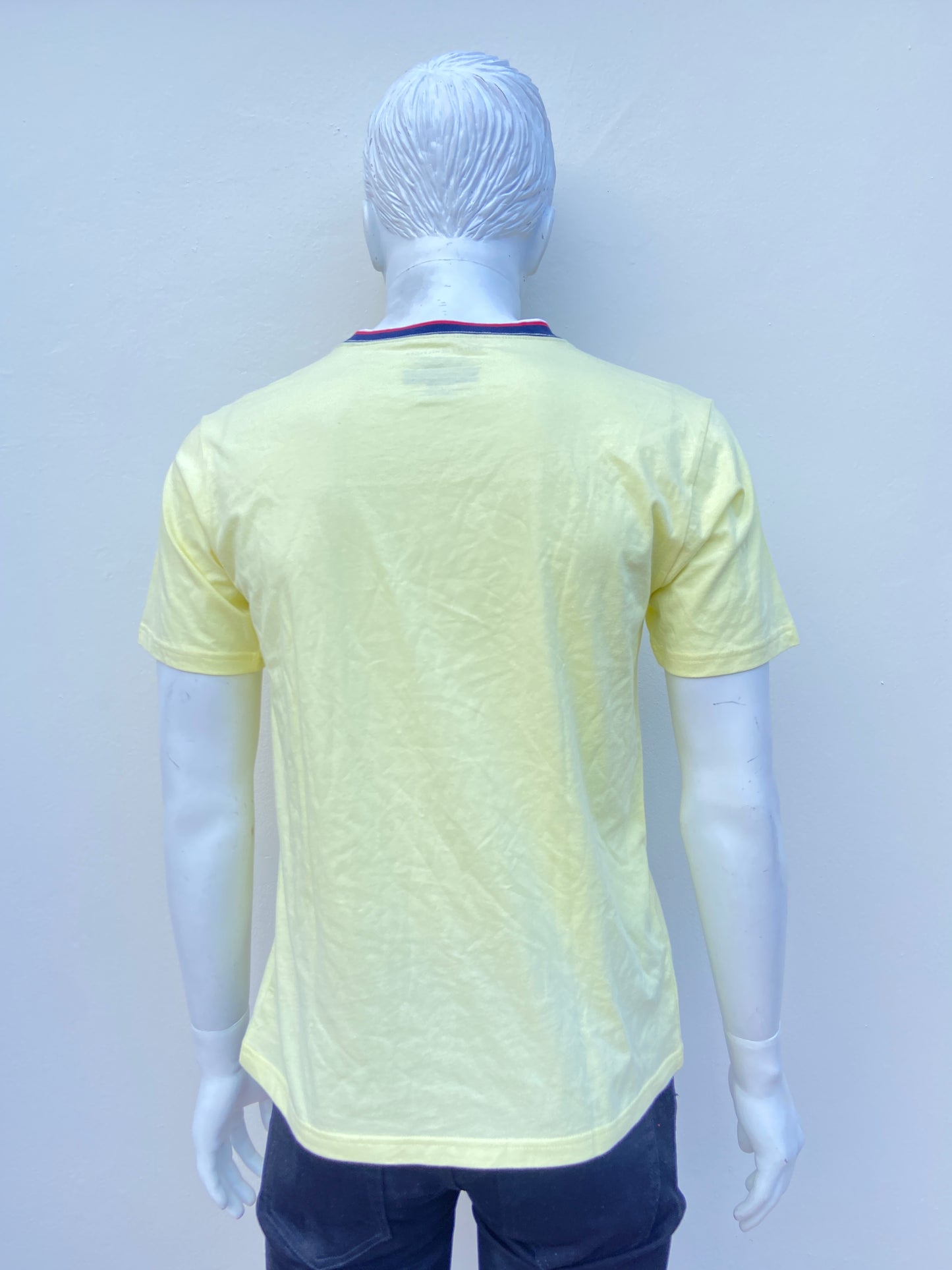 T-shirt Tommy Hilfiger Amarillo claro con logotipo de la marca al lado y cuello en color azul, rojo y blanco.