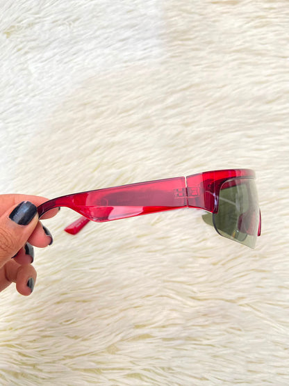Lentes, verde oliva con montura en rojo vino y micas claras, con protección UV 100%.