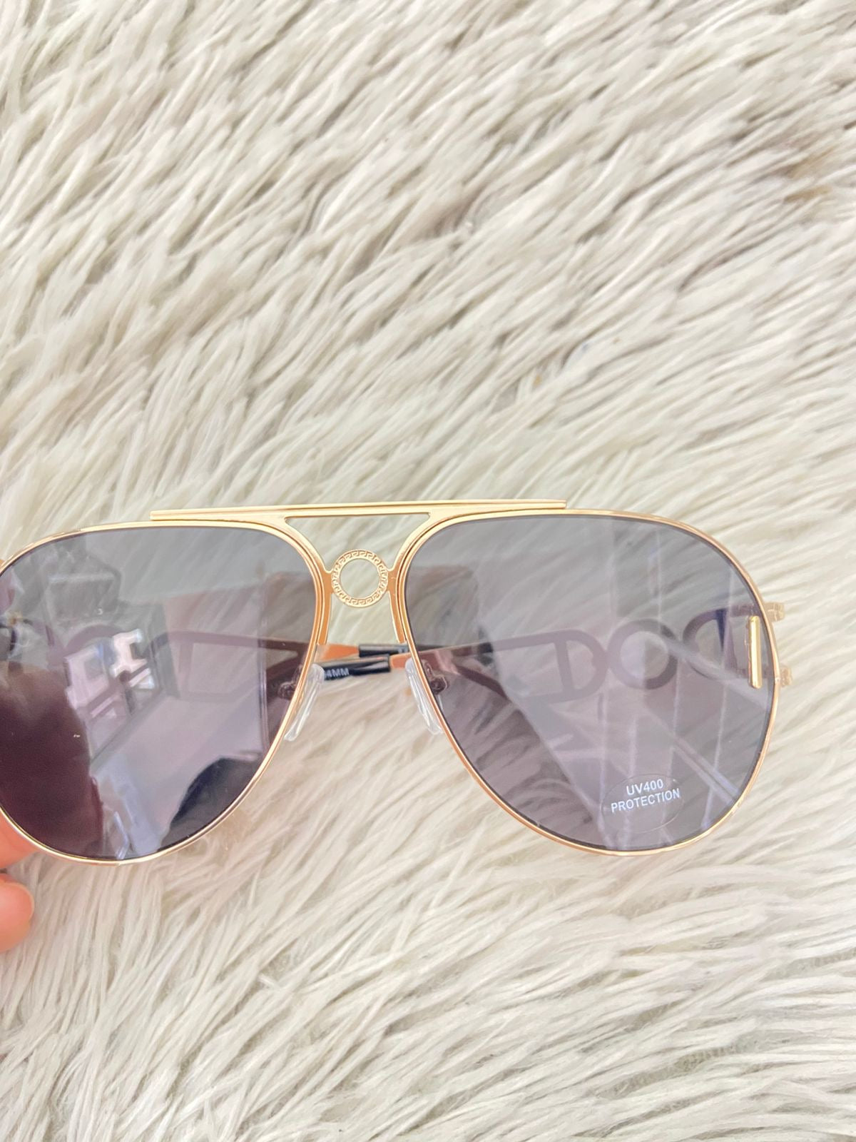 Lentes con montura en color dorado y detalles en los lados y micas oscuras