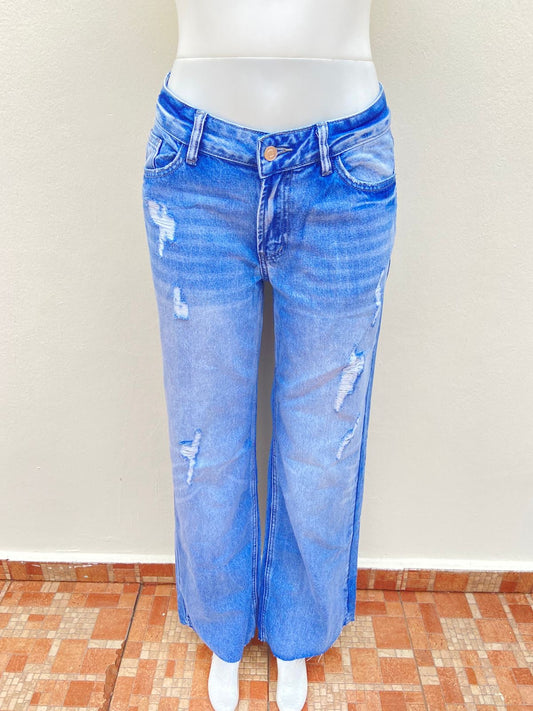 Pantalón Jean, azul claro ancho, con rasgados en la parte delantera y transera.