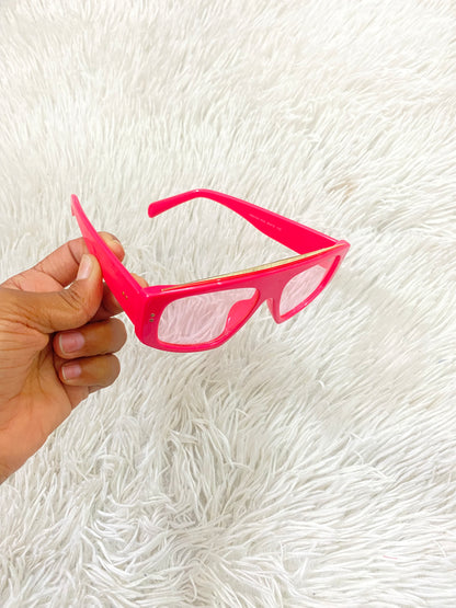 Lentes con protección UV 100-400 para proteger tu visión. Rosado fucsia con micas transparente y diseño dorado.