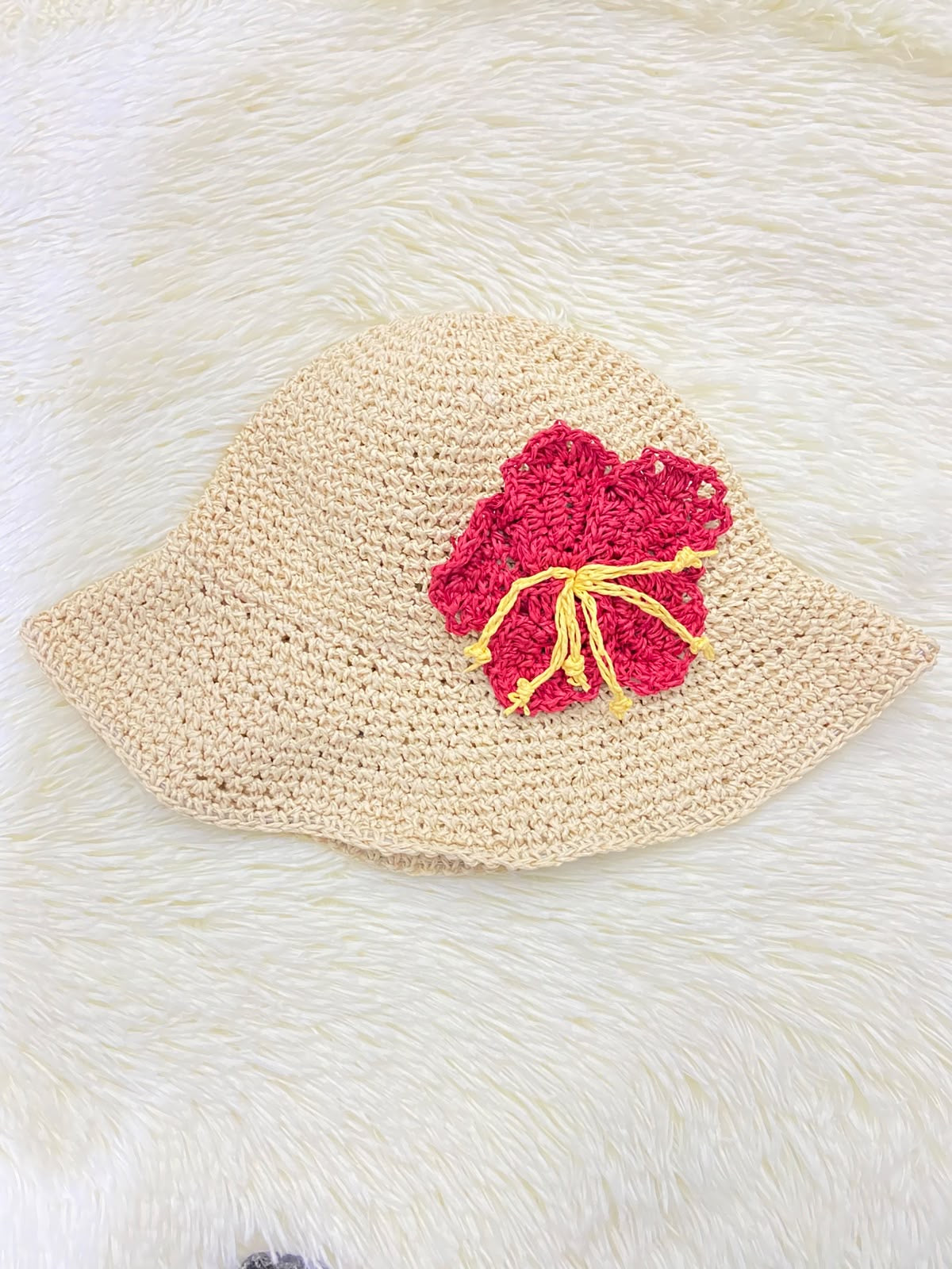 Sombrero, color crema y tejido artesanal estilo lana con flor roja con amarillo.