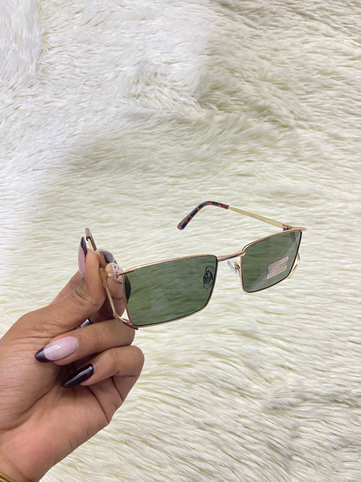 Lentes, con montura dorada y micas en color verde oscuro, con protección UV 100%.