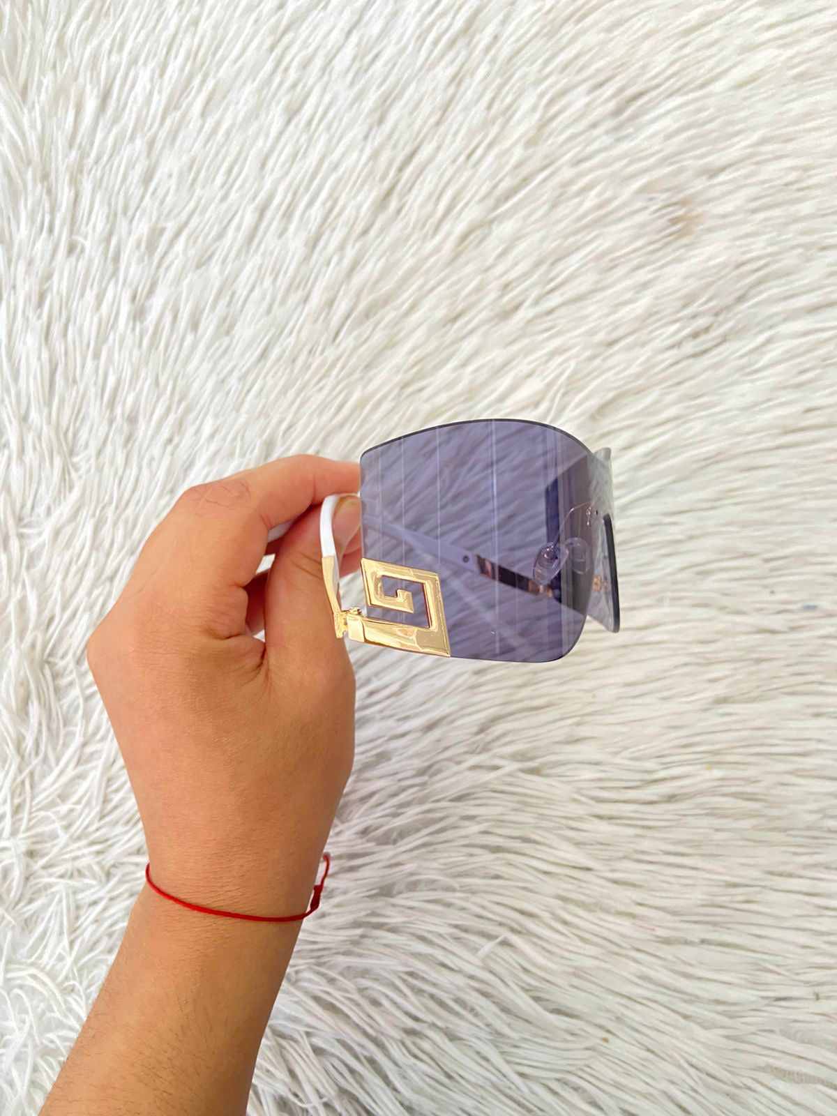 Lentes, negro con montura en color blanco y diseño de una G invertida dorada.