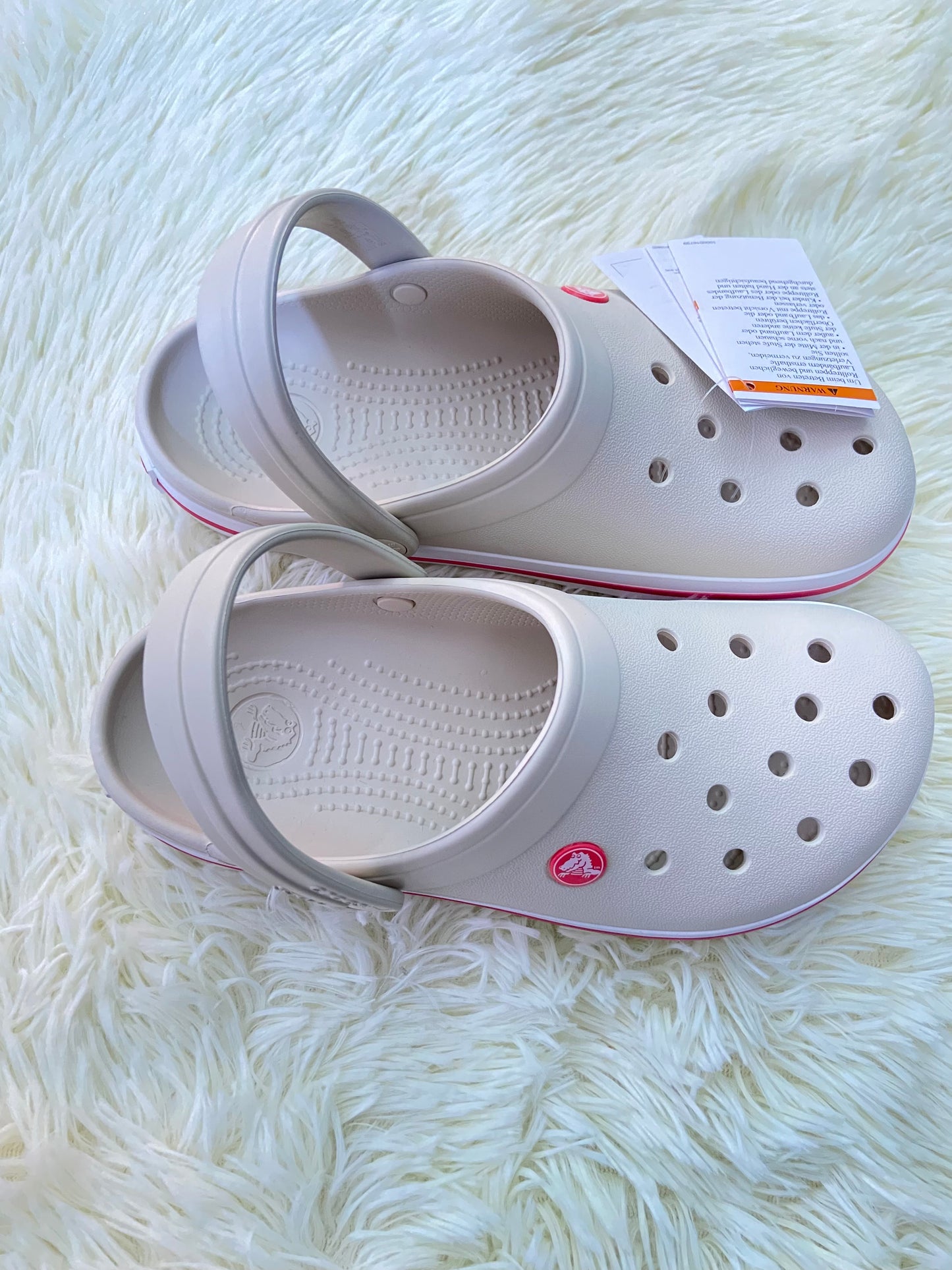 Sandalias CROCS original, crema con líneas rosadas y blancas.