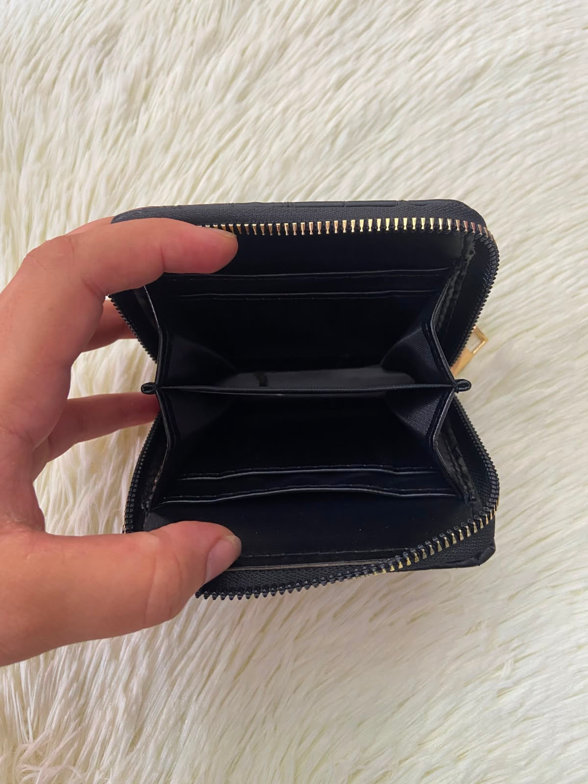 Monedero negro diseño acolchado, con cierre de zíper alrededor y super espacioso para tarjetas y más.