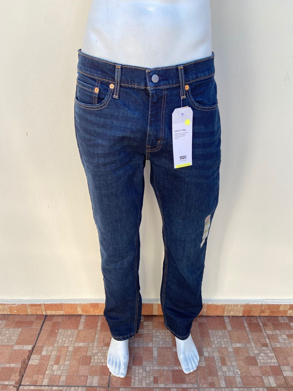 Pantalón Jean Levi’s original, azul oscuro liso, con costura en hilo marrón.